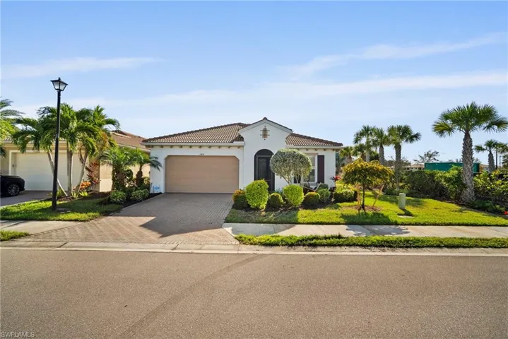 Mediterranean / spanish home featuring a front yard and a garage