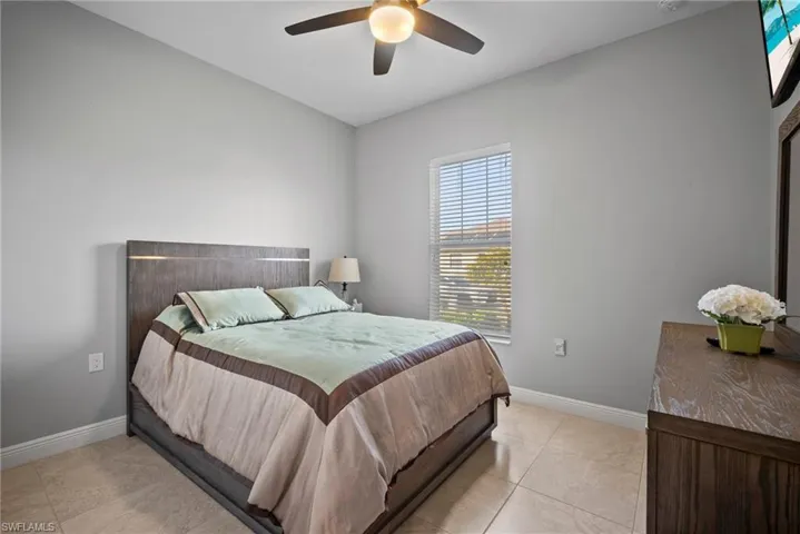 Bedroom with ceiling fan and light tile patterned floors