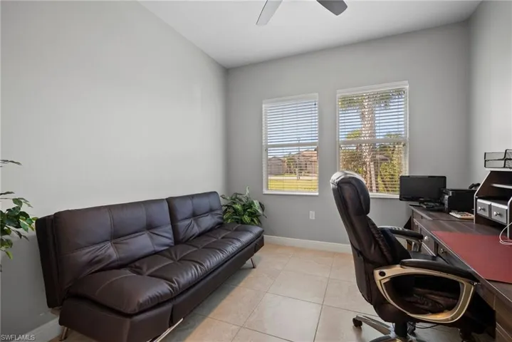 Tiled office space featuring ceiling fan