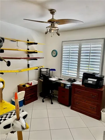 Second guest bedroom featuring a ceiling fan and light tile patterned flooring
