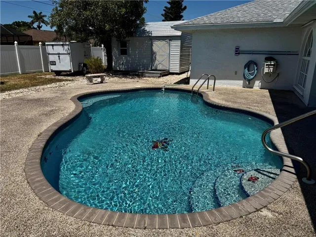 View of pool featuring a fenced in pool and shed