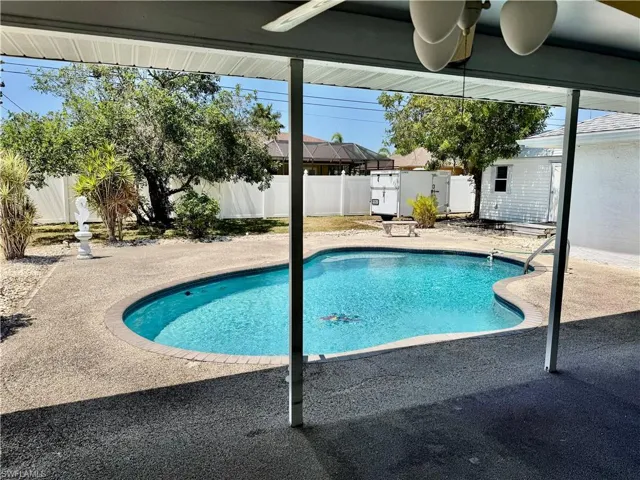 View of pool with an outdoor structure, a fenced backyard, a fenced in pool, and a patio area