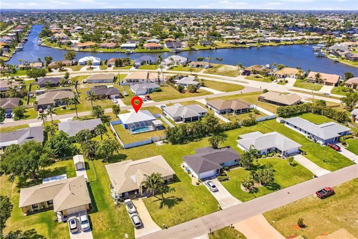 Aerial perspective of suburban area featuring a nearby body of water