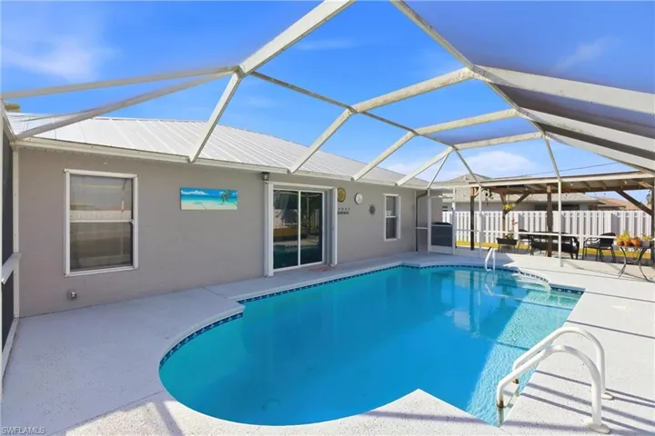 Swimming pool featuring a patio area, a sunroom, and glass enclosure