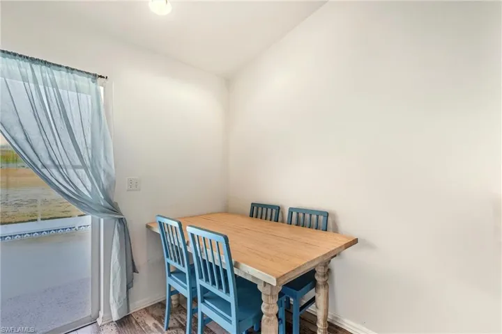 Dining area featuring wood finished floors and vaulted ceiling