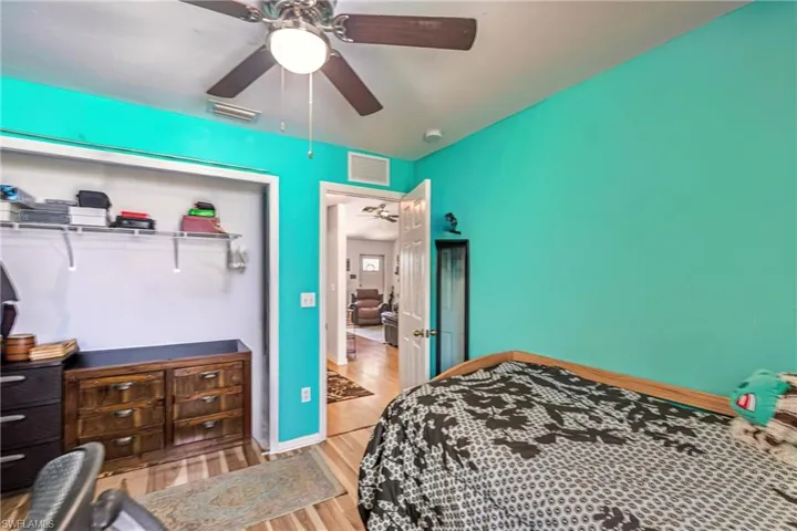 Bedroom with a closet, wood finished floors, and a ceiling fan