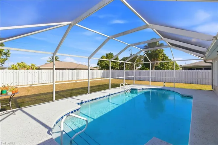 View of swimming pool with a sunroom, glass enclosure, and a fenced backyard