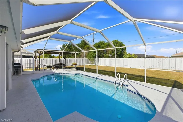View of pool featuring a sunroom, glass enclosure, a patio area, and a fenced backyard