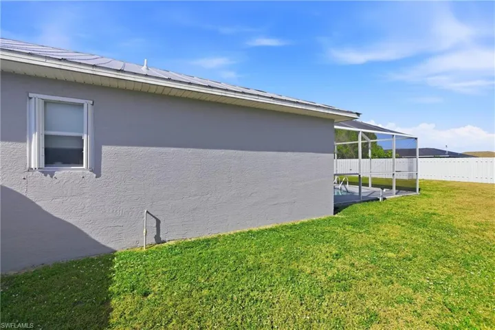 View of side of home with a lanai, a fenced backyard, and stucco siding