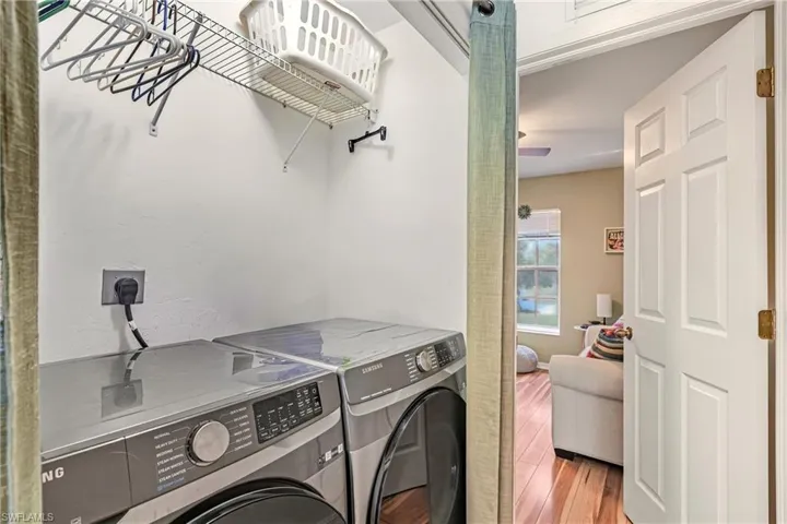 Laundry area featuring washer and clothes dryer and wood finished floors