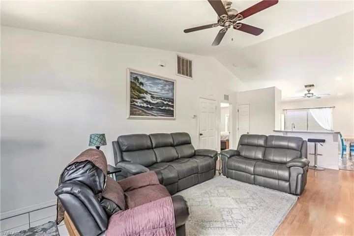 Living room with a ceiling fan and lofted ceiling