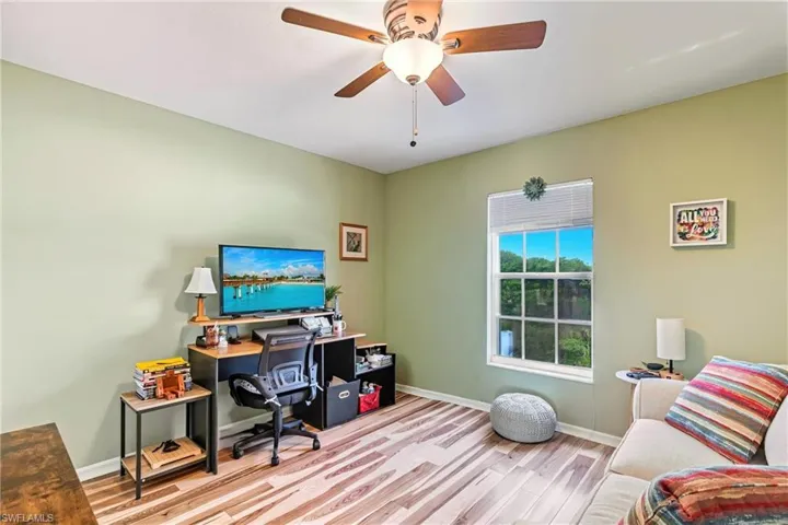 Home office with light wood finished floors and a ceiling fan