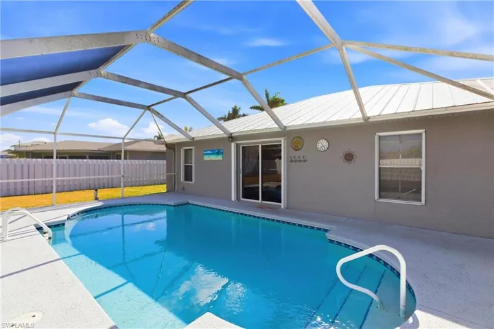 View of swimming pool with a sunroom, glass enclosure, and a patio