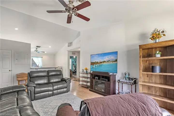 Living area with vaulted ceiling, ceiling fan, and wood finished floors