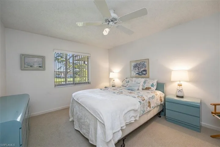 Carpeted bedroom featuring a textured ceiling and a ceiling fan