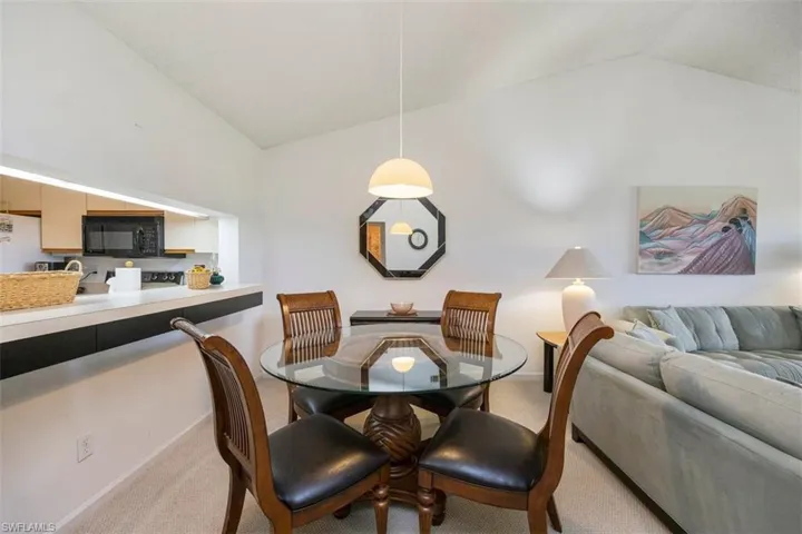 Dining room with vaulted ceiling and carpet floors