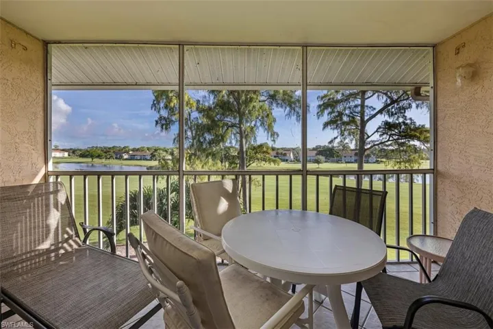 Sunroom featuring golf course view and a water view