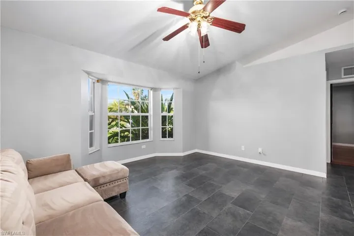 Living room featuring vaulted ceiling and ceiling fan