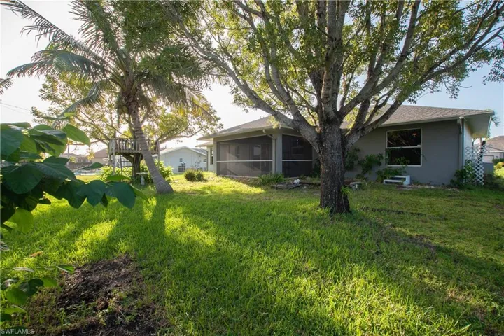 View of grassy yard with a sunroom