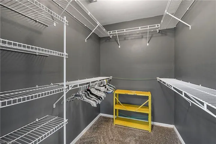 Walk in closet featuring dark carpet