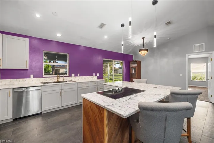 Kitchen with a kitchen breakfast bar, gray cabinets, dishwasher, pendant lighting, and light quartz countertops