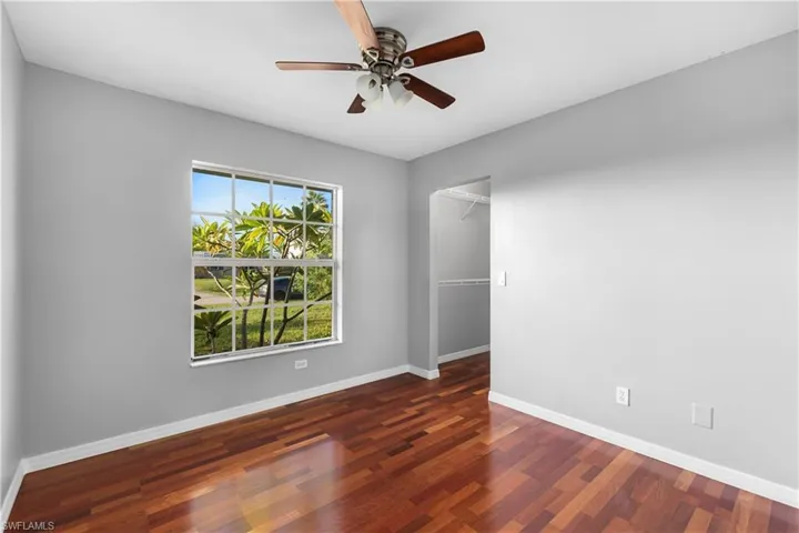 Spare room featuring dark wood flooring and ceiling fan