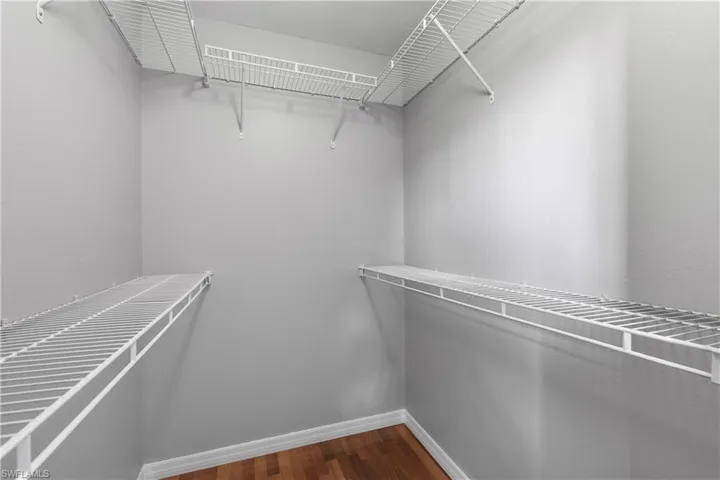Walk in closet featuring dark wood flooring