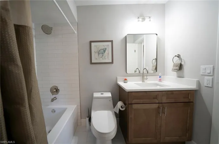 Full bathroom featuring tile patterned flooring, vanity, shower / tub combo with curtain, and toilet