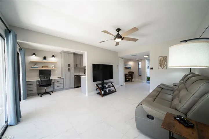Living room with ceiling fan and built in desk