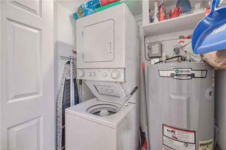 Clothes washing area featuring stacked washer / dryer, water heater, and hookup for an electric dryer