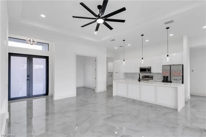 Kitchen featuring appliances with stainless steel finishes, modern cabinets, white cabinetry, light countertops, and light marble finish floors