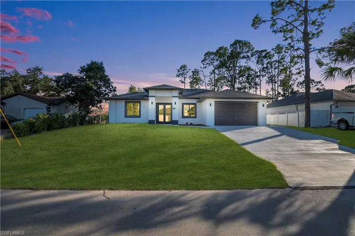 Prairie-style house featuring driveway, an attached garage, and stucco siding