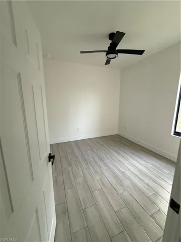Spare room featuring wood tiled floors and a ceiling fan