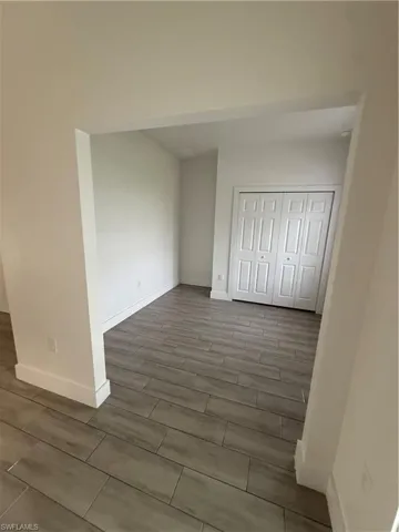 Unfurnished bedroom with wood finish floors and a closet