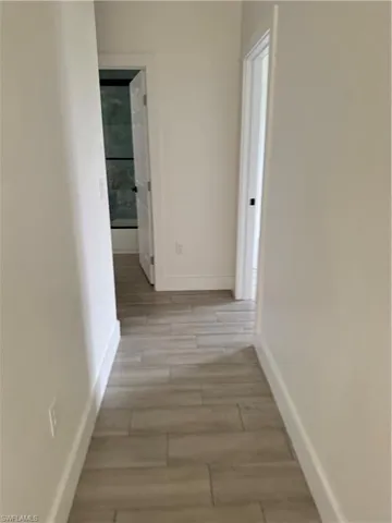 Hall with baseboards and wood tiled floors