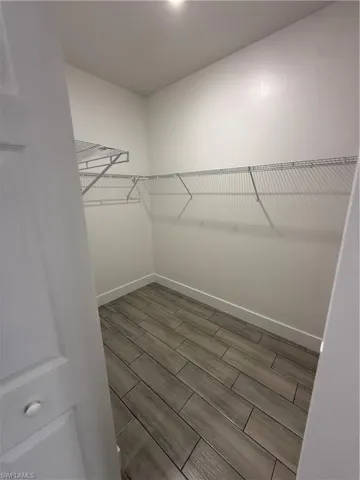 Spacious closet featuring wood finish floors
