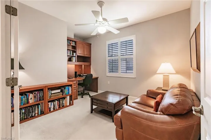 Living room with light carpet, a desk, and ceiling fan