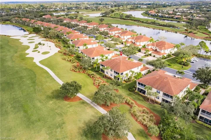 Aerial view of residential area featuring a nearby body of water and a golf course