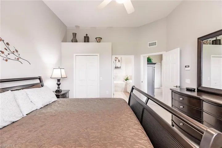 Bedroom featuring a closet, ensuite bath, and ceiling fan