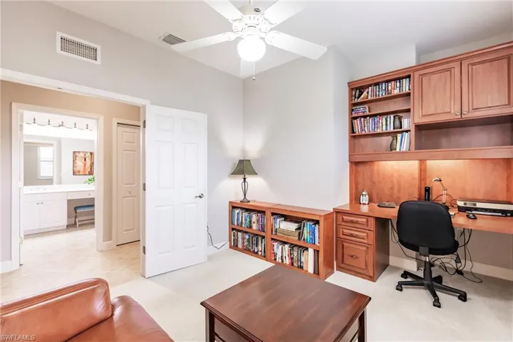 Office area featuring built in study area, a ceiling fan, and light carpet