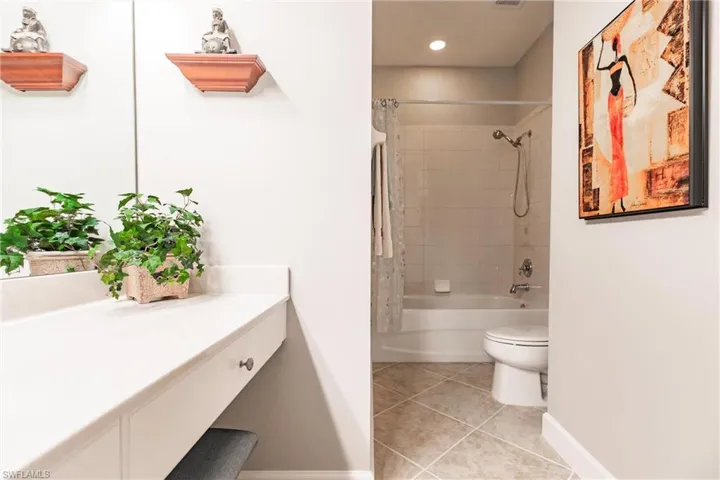 Full bathroom featuring shower / bath combo with shower curtain, light tile patterned flooring, and recessed lighting