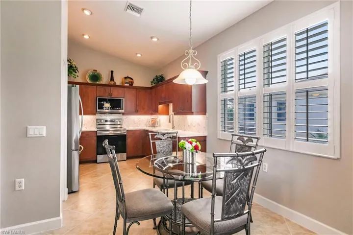Dining room featuring light tile patterned floors, recessed lighting, and lofted ceiling