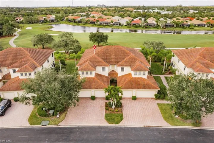Aerial view of residential area featuring a nearby body of water and a golf club