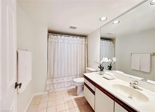 Full bath featuring recessed lighting, vanity, and light tile patterned flooring