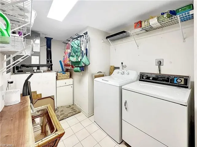 Laundry area featuring light tile patterned flooring and independent washer and dryer