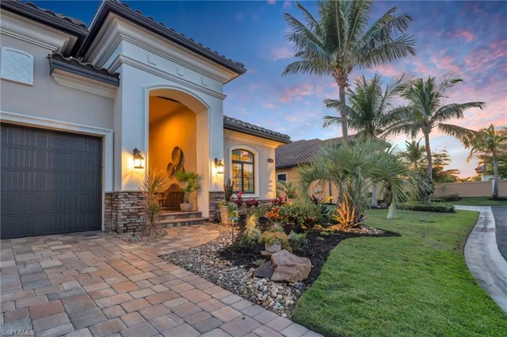 Exterior entry at dusk featuring a garage and a yard