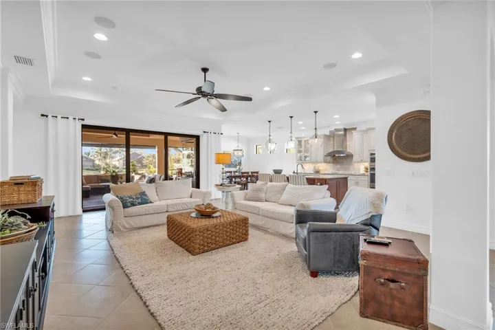 Tiled living room with a tray ceiling and ceiling fan