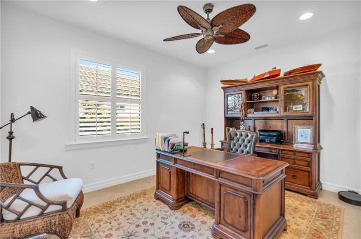 Home office with light tile patterned floors and ceiling fan