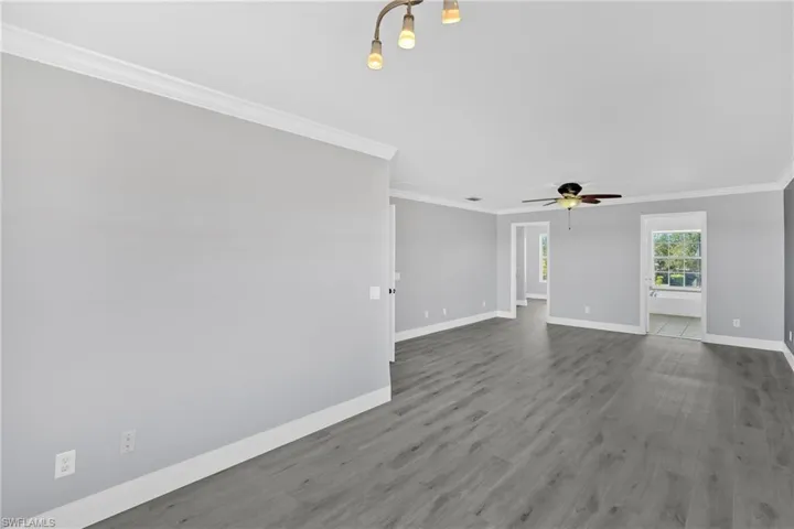 Spare room featuring ornamental molding, wood finished floors, and a ceiling fan