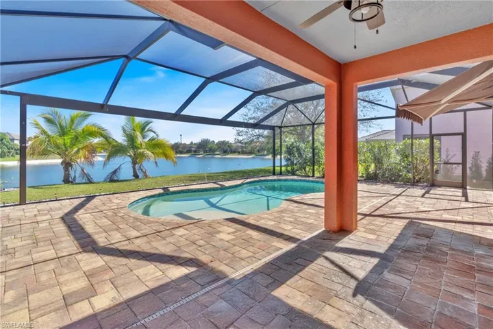 Swimming pool with a patio, a lanai, a sunroom, and a water view